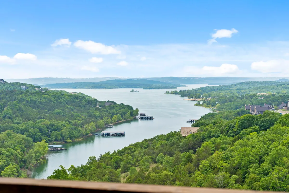 A serene view of the lake with lush greenery, boats, and rolling hills in the distance. The image embodies tranquility and outdoor adventure, suggesting nearby lake access and boating opportunities.