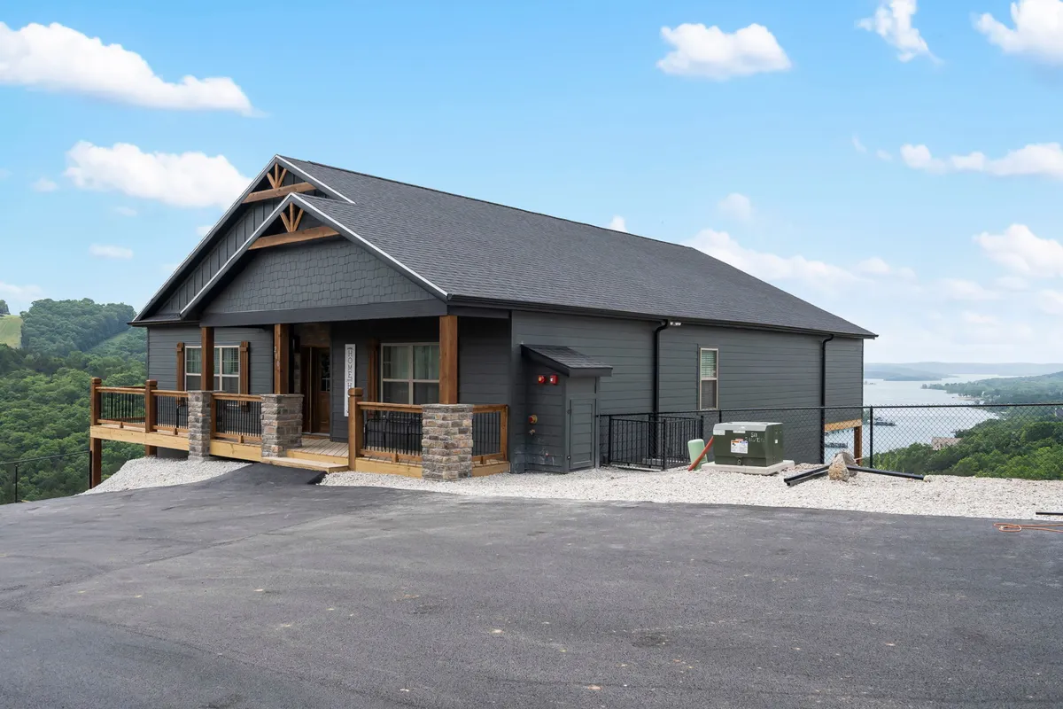 A modern cabin with a wooden deck set against a scenic lake backdrop. The image emphasizes outdoor living, relaxation spaces, and the dramatic beauty of Table Rock Lake, with seating that invites guests to gather for sunset, stargazing, or lakeside conversations.