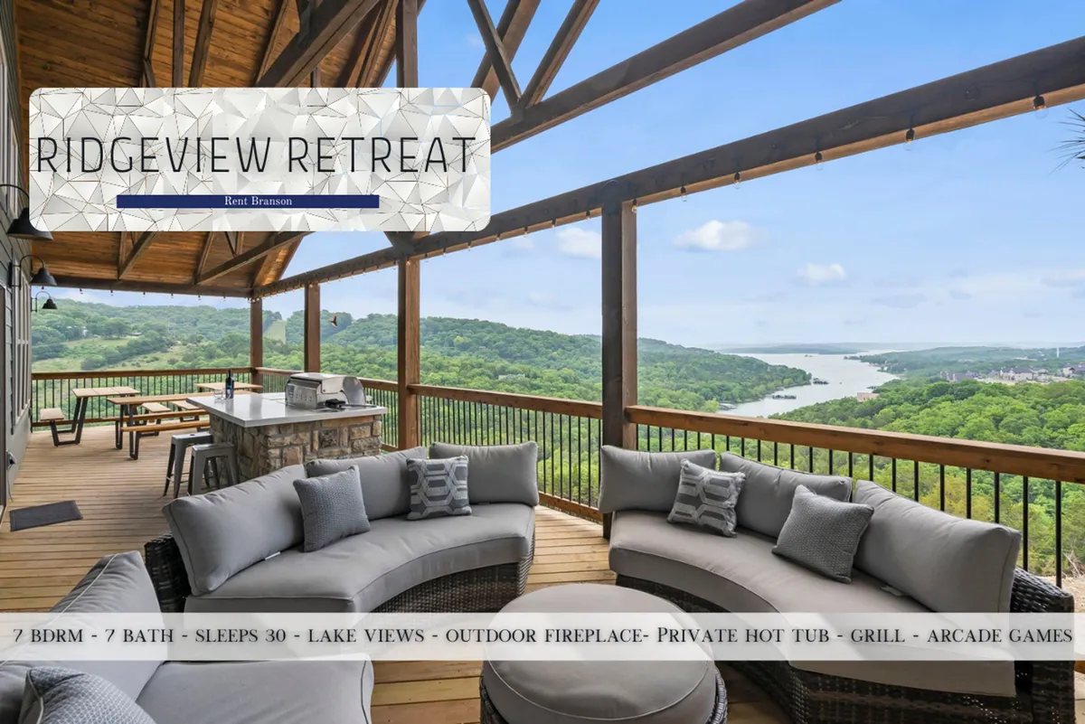 A tranquil exterior space with a curved sectional sofa, outdoor kitchen, and breathtaking lake views. Wooden beams frame the scene, while the hot tub invites relaxation after a day of exploration.
